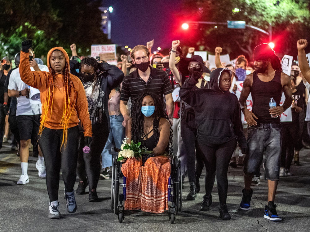 Whitney Mitchell (center), Garrett Foster's fiancée, leads a march for Foster in July of 2020, after Foster was shot and killed at a Black Lives Matter protest. Sgt. Daniel Perry has been found guilty of murdering Foster — but Gov. Greg Abbott wants to pardon Perry.