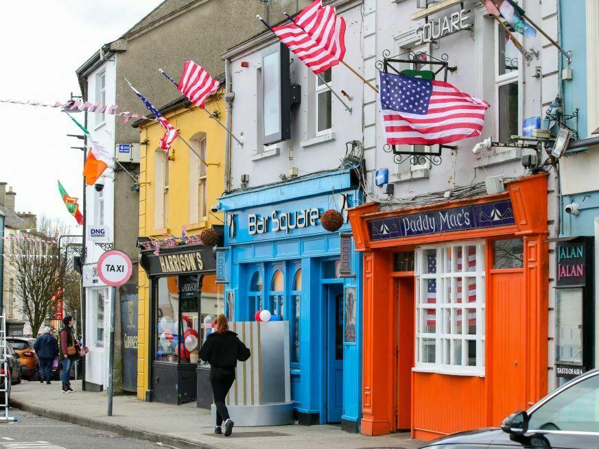 United States flags flutter in the breeze above shops in Ballina town center on April 7 as the town prepares to welcome President Biden in County Mayo, his ancestral home.