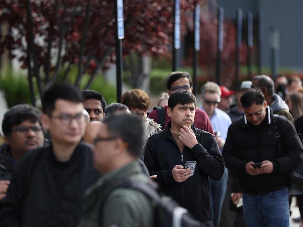 People line up outside of a Silicon Valley Bank office in Santa Clara, Calif., on March 13, 2023.  in Santa Clara, California. Depositors lined up to retrieve their money even after after regulators rescued the tech-focused lender.