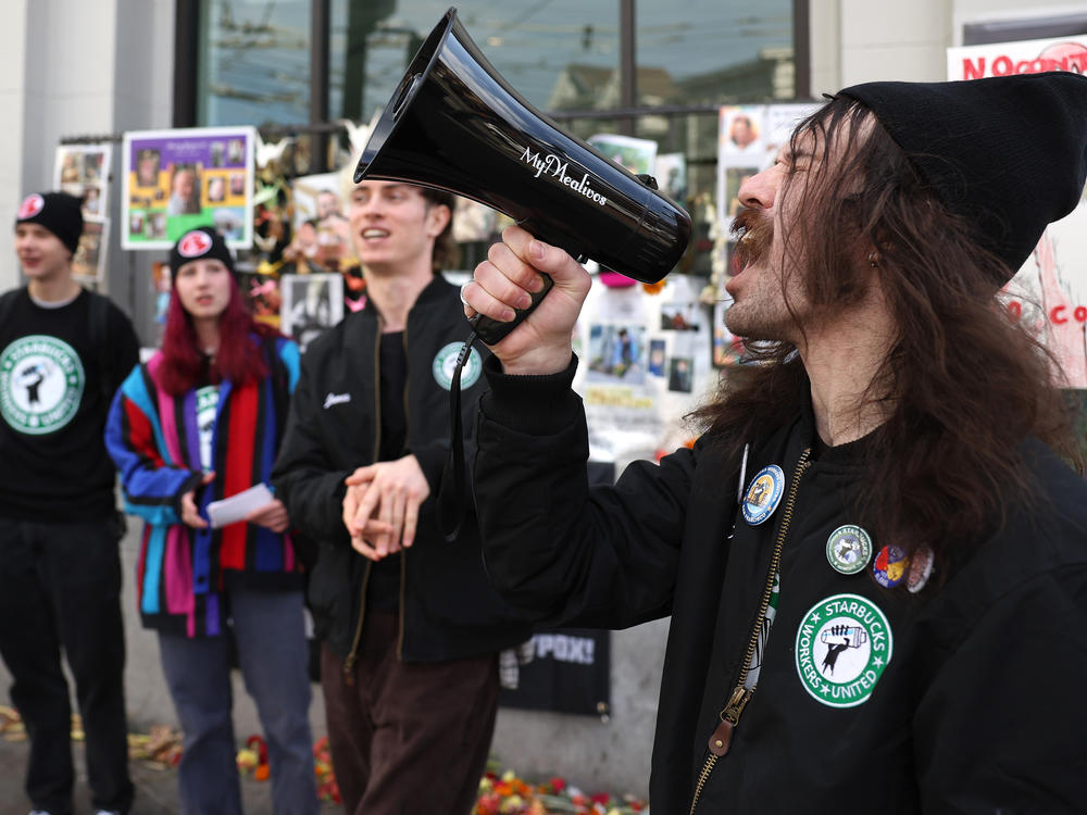 Striking Starbucks worker Kyle Trainer uses a megaphone outside of a Starbucks coffee shop during a national strike on November 17, 2022 in San Francisco, California.