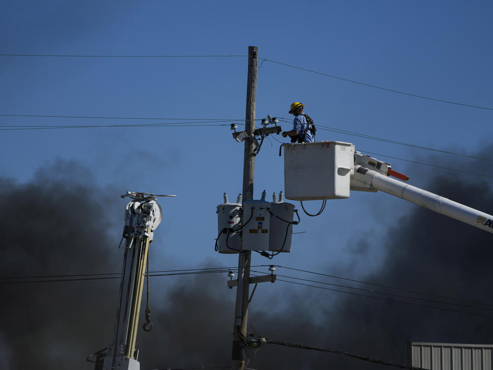 Utility workers are seen working near an industrial fire in Richmond on Wednesday.