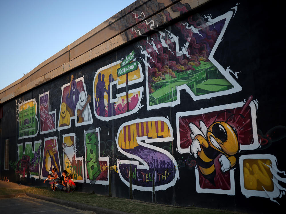 A mural marking Black Wall Street, also called the Greenwood District, in Tulsa, Okla. The Tulsa Race Massacre in 1921 devastated Black Wall Street and claimed some 300 African American lives.