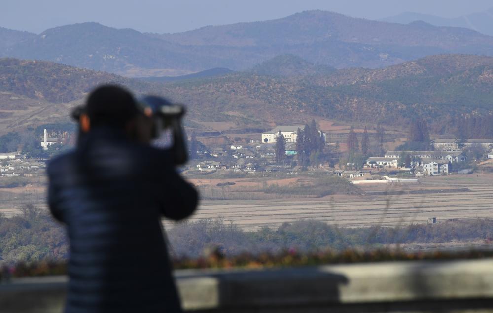 A woman looks through binoculars toward North Korea from a South Korean observation post in Paju near the Demilitarized Zone dividing the two Koreas, in November 2017.