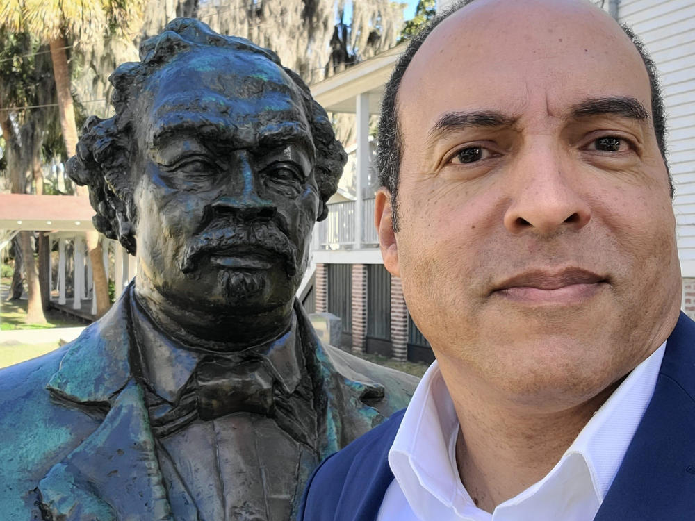 Michael Moore takes a selfie with a statue of his great-great-grandfather, the Union Navy hero Robert Smalls.