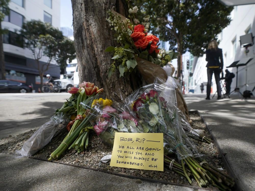 Flowers sit at a tree in front of the building where technology executive Bob Lee was fatally stabbed in San Francisco last week.