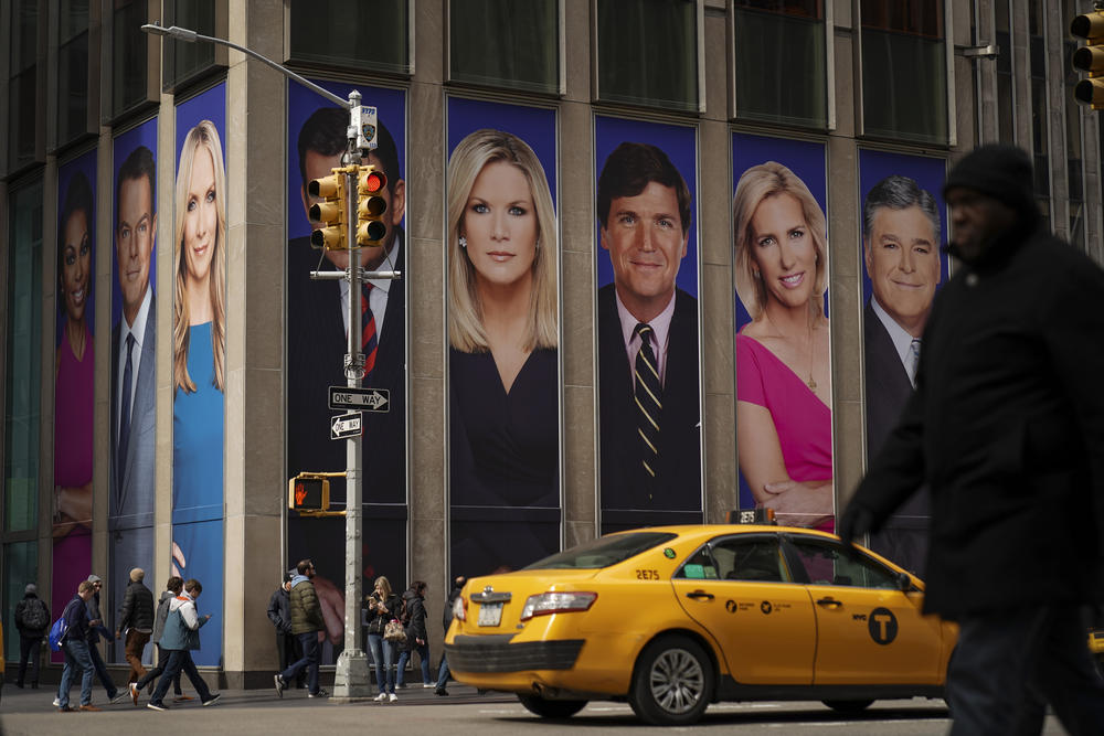 Advertisements featuring Fox News personalities, including Tucker Carlson, adorn the front of the News Corporation building in a 2019 file photo. The cable channel faces a defamation suit going to trial next week based on lies it aired about Dominion Voting System's role in the 2020 election.