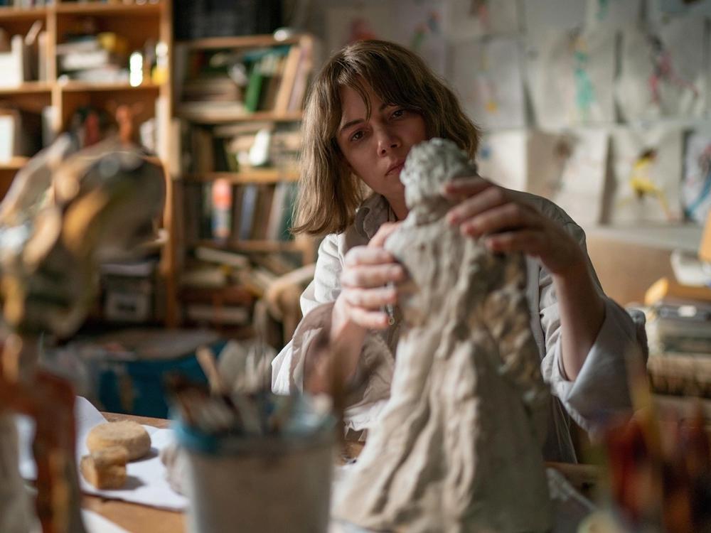 Michelle Williams is a sculptor who makes clay figures of women in <em>Showing Up.</em>