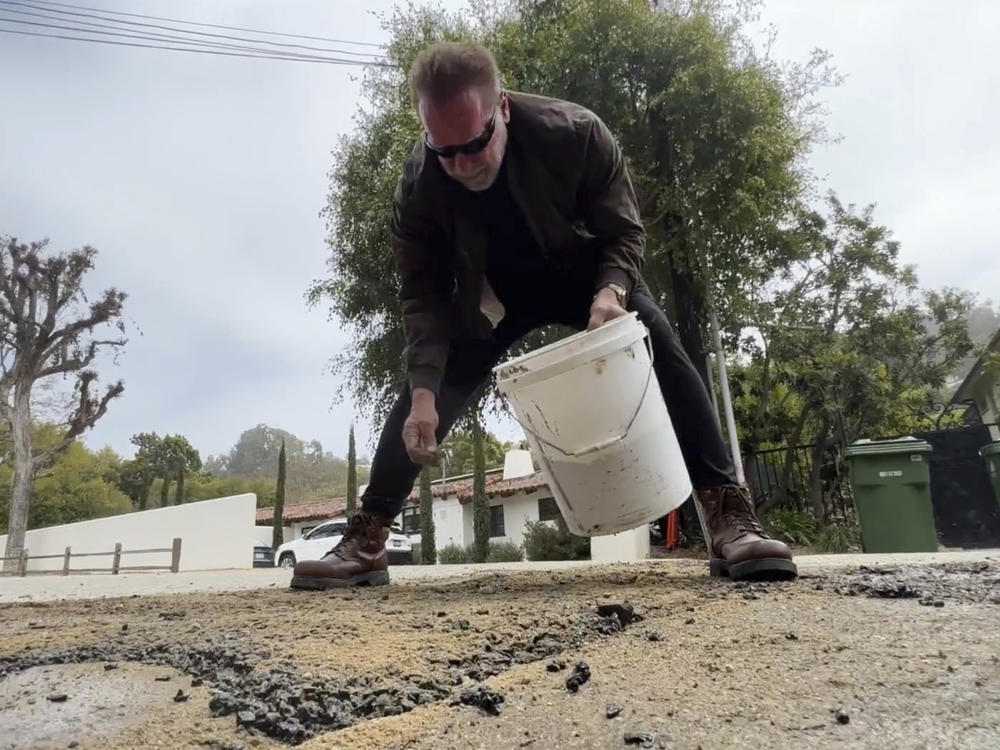This video still image provided by The Office of Arnold Schwarzenegger, shows former California Governor Arnold Schwarzenegger, repairing what he called a pot hole on a street in his Los Angeles neighborhood on Tuesday, April 11, 2023.