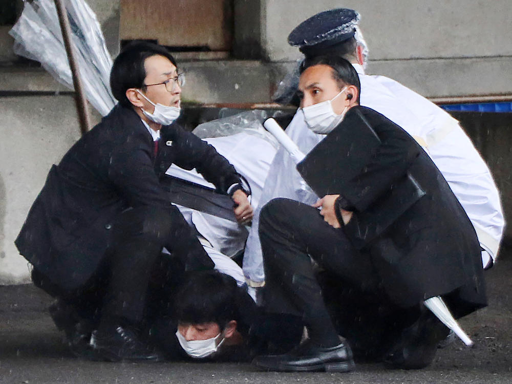 A person (bottom) is detained after throwing an apparent 