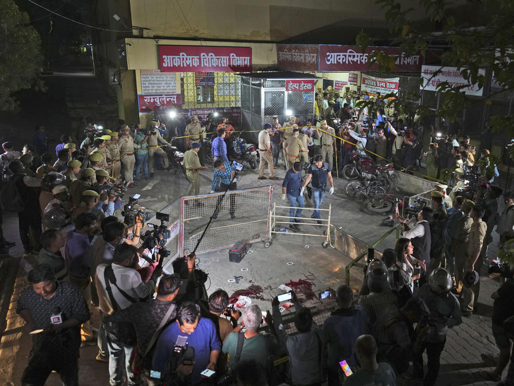 Police and media surround the area where Gangster-turned-politician Atiq Ahmad and his brother Ashraf were shot in front of the Motilal Nehru medical college in, Prayagraj, India, Saturday, April 15, 2023.
