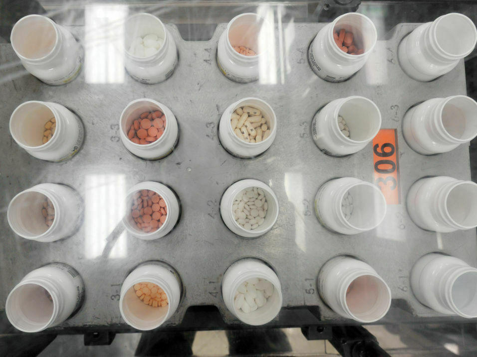 Bottles of prescription pills go through an automated packaging machine in a pharmacy plant. The Supreme Court on Tuesday hears a case that considers whether pharmacies knowingly overcharged Medicare and Medicaid under the False Claims Act.
