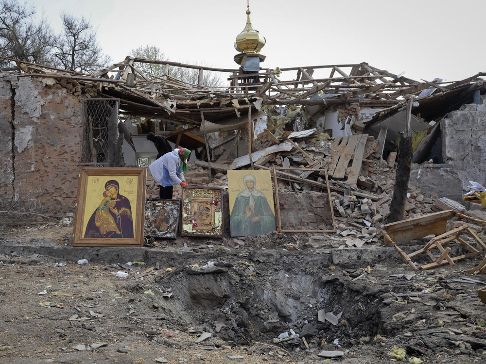 People save icons as they clear rubble after a Russian rocket ruined an Orthodox church in an Easter attack, in Komyshuvakha, in Ukraine's Zaporizhzhia region, early hours Sunday.