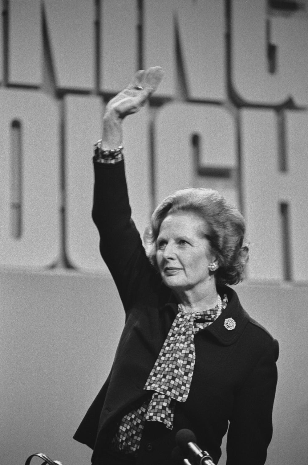 British Prime Minister Margaret Thatcher waves from the podium at the Conservative Party Conference in Brighton in October 1984.