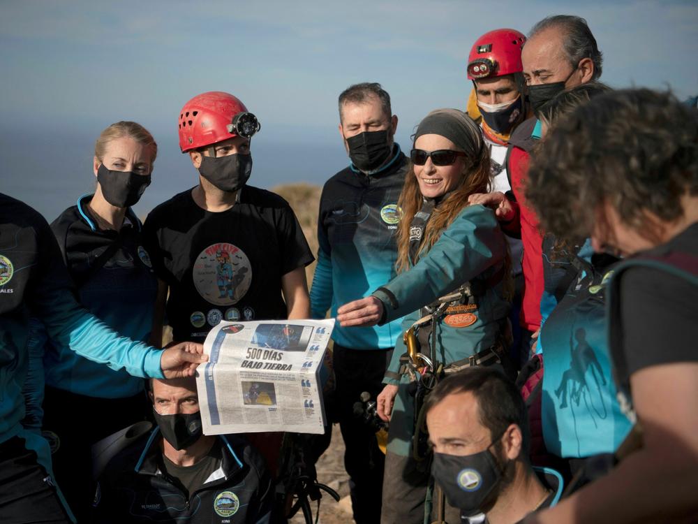Flamini and members of her team pose with a newspaper after she left the cave on Friday.
