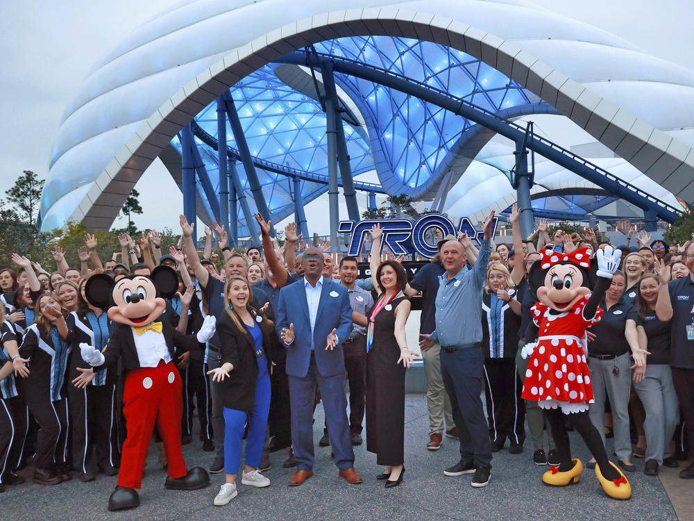 Mickey, Minnie and cast members join Walt Disney World executives in a ceremony marking the official opening of Tron Lightcycle / Run at the Magic Kingdom in early April.