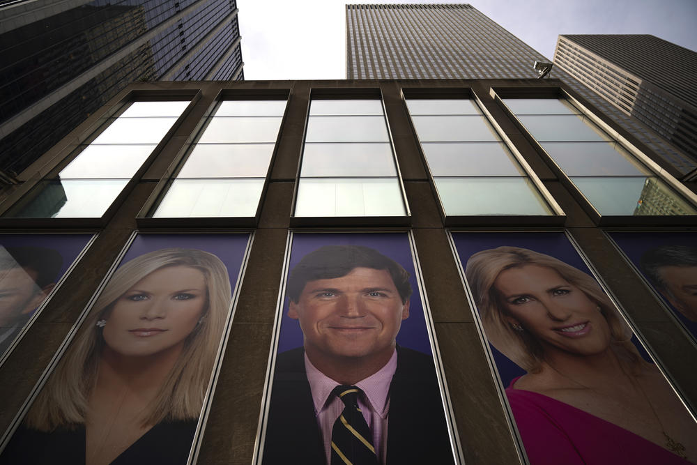 Advertisements featuring Fox News personalities, including Tucker Carlson, center, adorn the front of the channel's headquarters in a 2019 file photo.