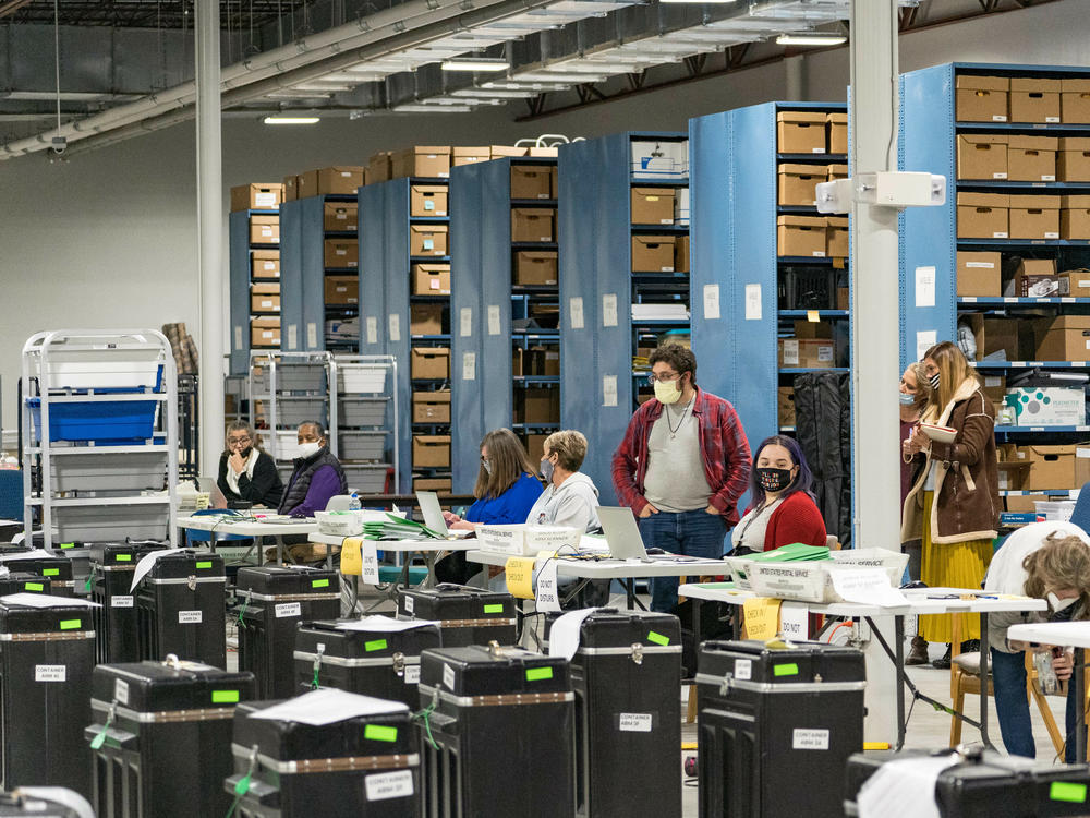 Gwinnett County election workers prepare to handle ballots as part of the recount for the 2020 presidential election on Nov. 16, 2020, in Lawrenceville, Georgia. Nearly two and a half years after the election, voting machine companies, election workers and even a local postmaster have filed defamation cases tied to conspiracy theories that have spread about the election.