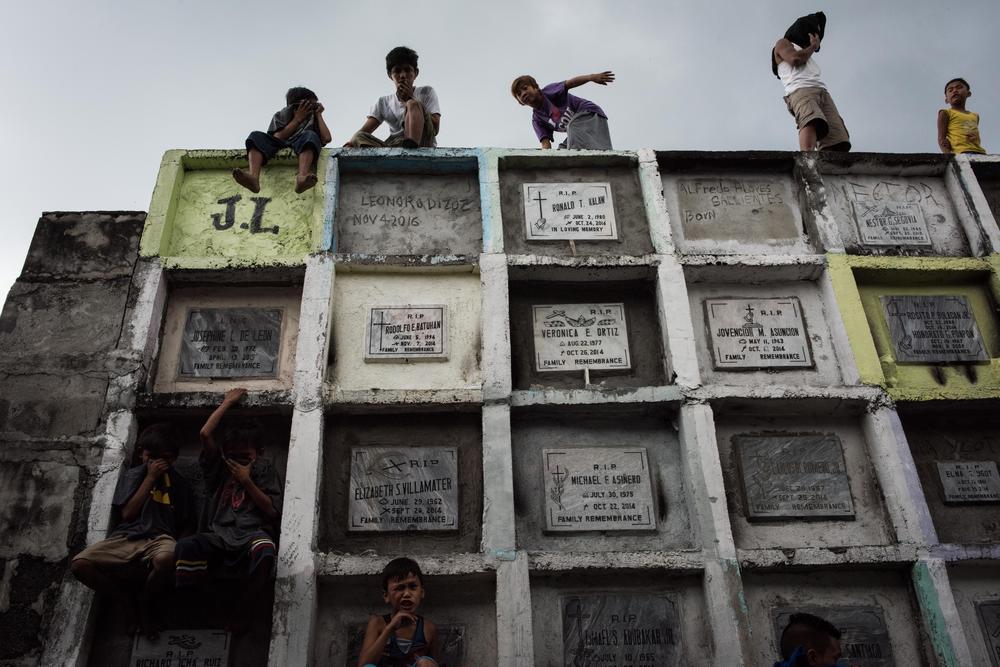 Shanty dwellers living inside the cemetery look at bodies being buried on Jan. 24, 2017 in Manila, Philippines. Many bodies of victims of extrajudicial killings lie unclaimed in a morgue amid an upsurge in fatalities from the drug war.