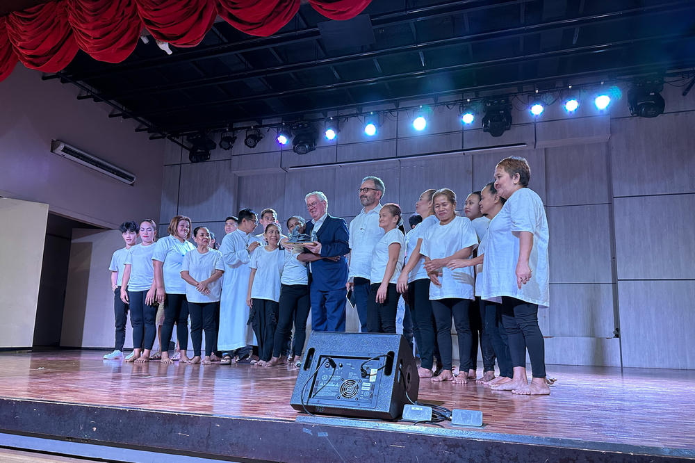 The cast of <em>EJK Teatro</em> poses onstage with Roman Catholic priest Flaviano Villanueva (5th from left), founder of Program Paghilom, and European Union Special Representative on Human Rights Eamon Gilmore (center) following a performance.
