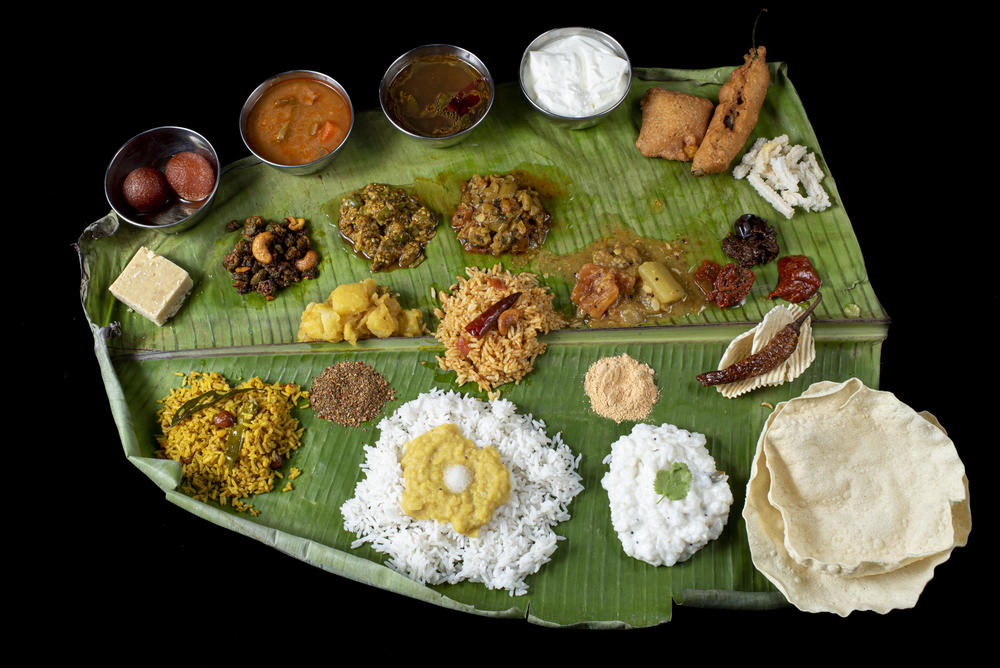 An Andhra-style platter is neatly arranged with an assortment of curries, fried vegetables, <em>pappu</em> (lentils), <em>sambar</em> (a lentils-based spicy stew), <em>rasam</em> (a tangy spiced broth), <em>perugu</em> (yogurt), pickles, chutneys, spicy 