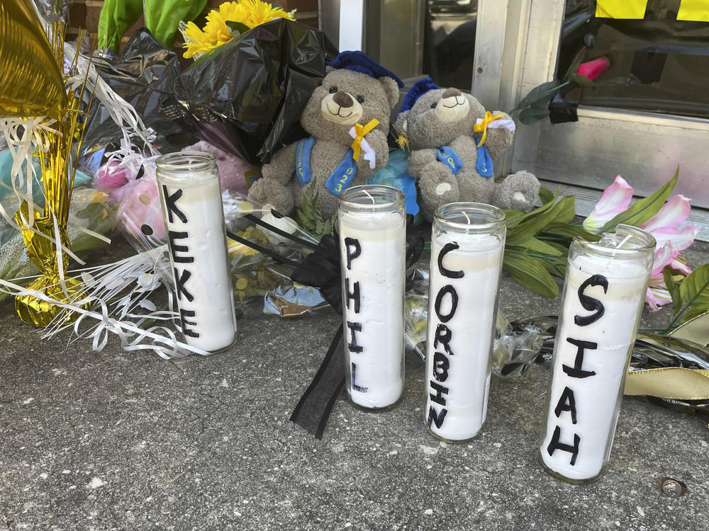Candles with the names of the four young people killed in a shooting and teddy bears dressed in graduation caps sit outside the Mahogany Masterpiece dance studio on Wednesday, in Dadeville, Ala.