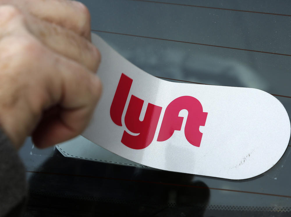 A Lyft logo is installed on a Lyft driver's car in Pittsburgh. The company announced this week that its making major cuts to its staff in a cost-saving move.
