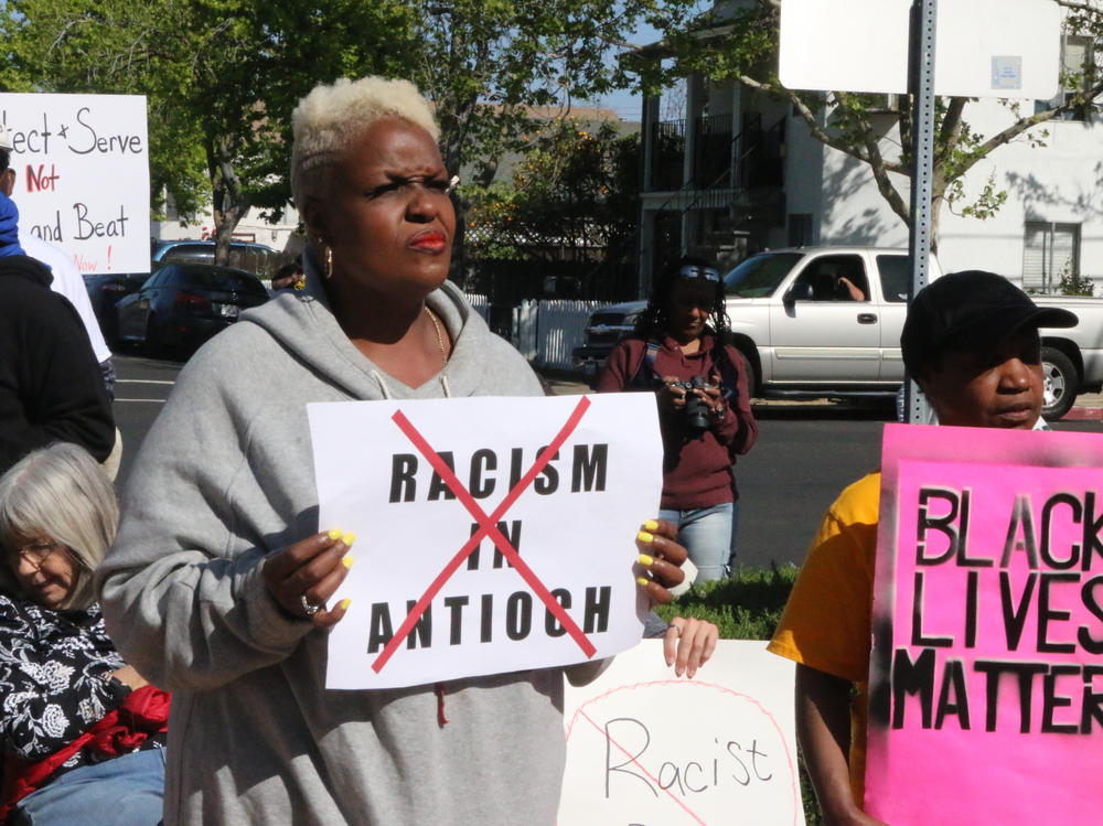 Kiora Hansen and Della Currie protest against racism by Antioch police officers at a rally in front of the police department on Tuesday.