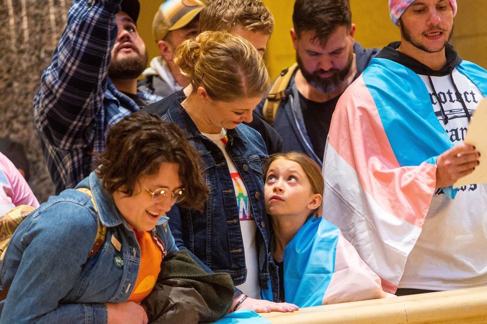 Bella Mendez, 8, stands with her mother during a Trans Day of Visibility rally at the Minnesota State Capitol building on March 31, 2023.