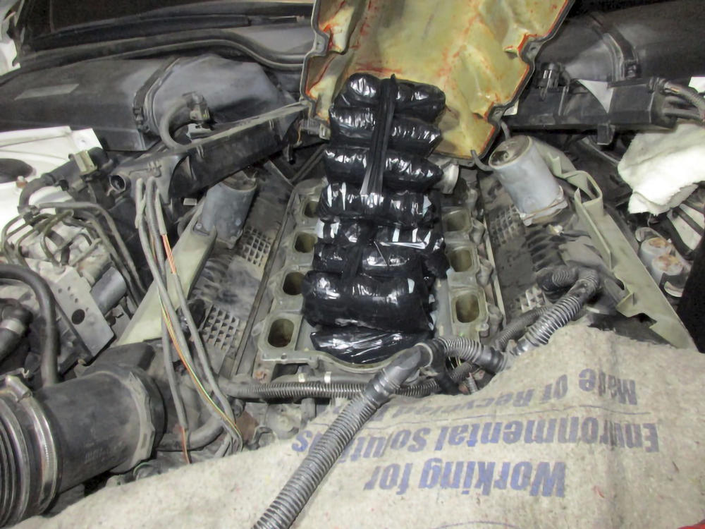 This Sept. 12, 2021 photo provided by the U.S. Customs and Border Protection shows drugs concealed inside the engine of a car.