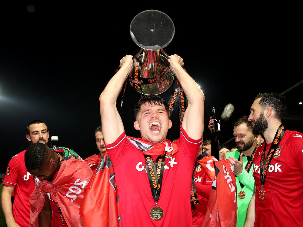 Jordan Davies of Wrexham celebrates with the Vanarama National League trophy as Wrexham win the Vanarama National League and are promoted to the English Football League after victory at Racecourse Ground on Saturday in Wrexham, Wales.