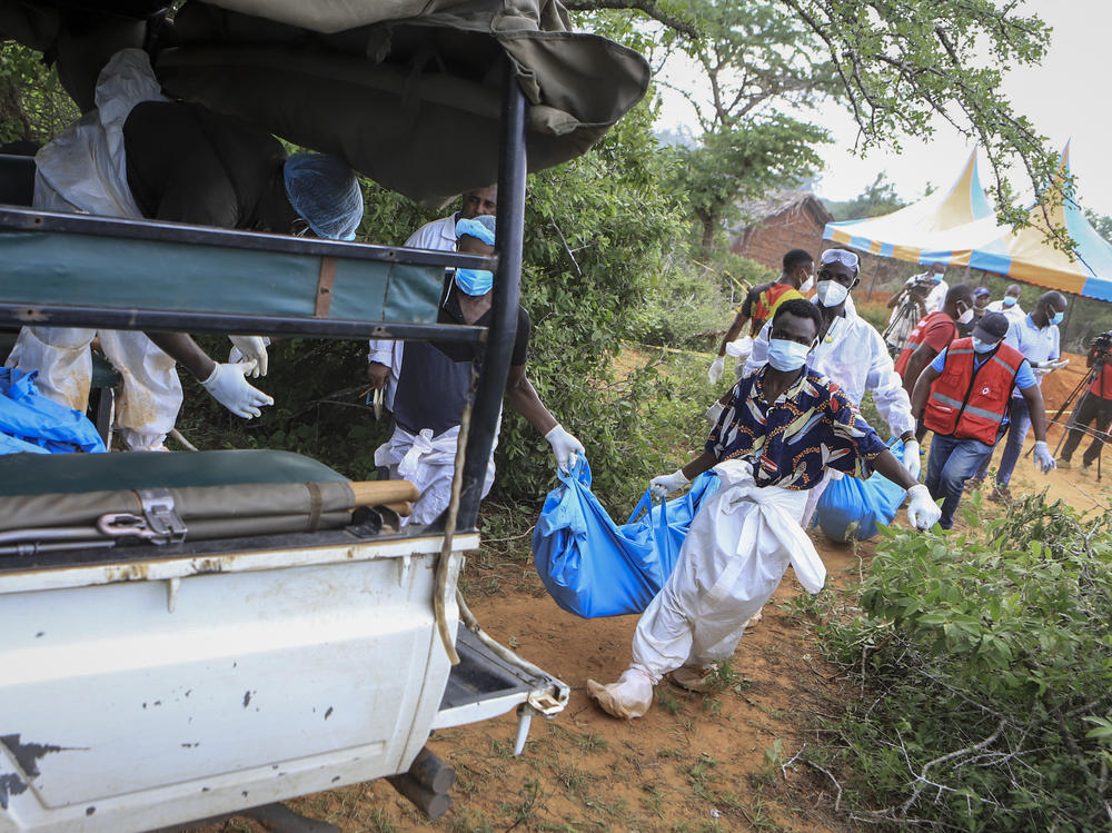 Police and local residents load the exhumed bodies of victims of a religious cult into the back of a truck in the village of Shakahola, near the coastal city of Malindi, in southeastern Kenya on Sunday.