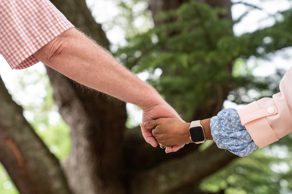 Families hold hands during a healing circle at the Finding Our Voice program Saturday.