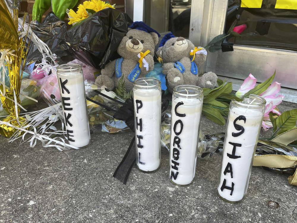 Candles with the names of the four young people killed in a shooting and teddy bears dressed in graduation caps sit outside the Mahogany Masterpiece dance studio on Wednesday, April 19, 2023, in Dadeville, Ala.