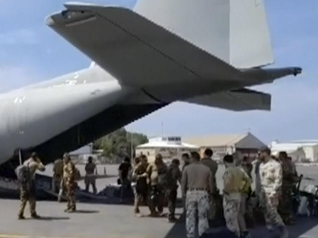 Italian Defense Ministry personnel prepare to evacuate foreign nationals from the airport in Khartoum on Sunday.