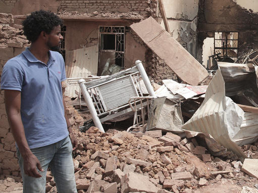 A man walks by a house hit in fighting in Khartoum, Sudan, on Tuesday.