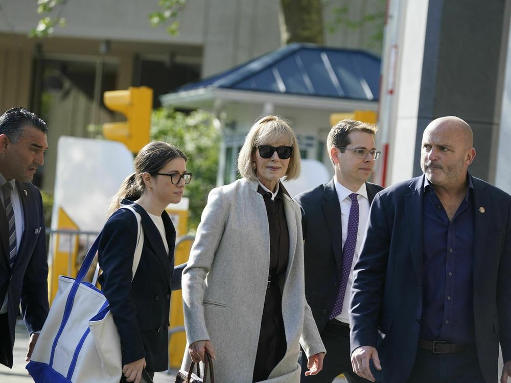 Writer E. Jean Carroll (center) arrives at Manhattan federal court on the first day of her defamation case against former President Donald Trump. She's accused him of raping her in a department store dressing room in the 1990s.