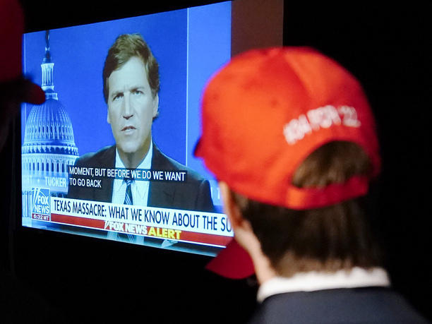 Supporters at a Herschel Walker election night watch party last year watching former Fox News host Tucker Carlson.