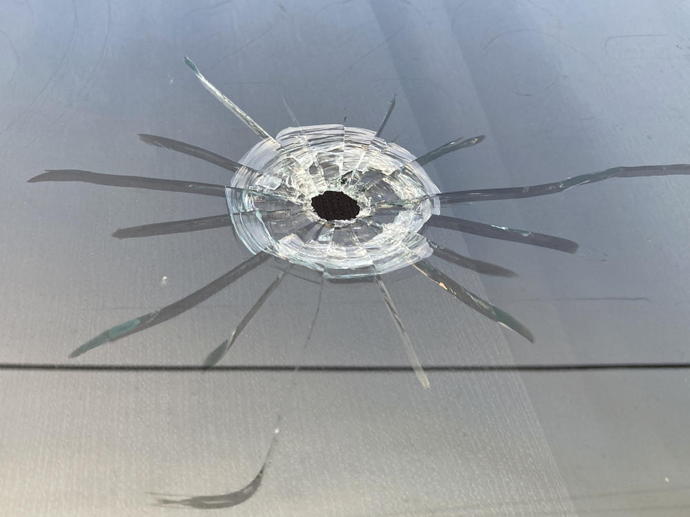 A bullet hole is visible in the glass transom over the door at the Mahogany Masterpiece dance studio in Dadeville, Ala., on April 16, 2023.