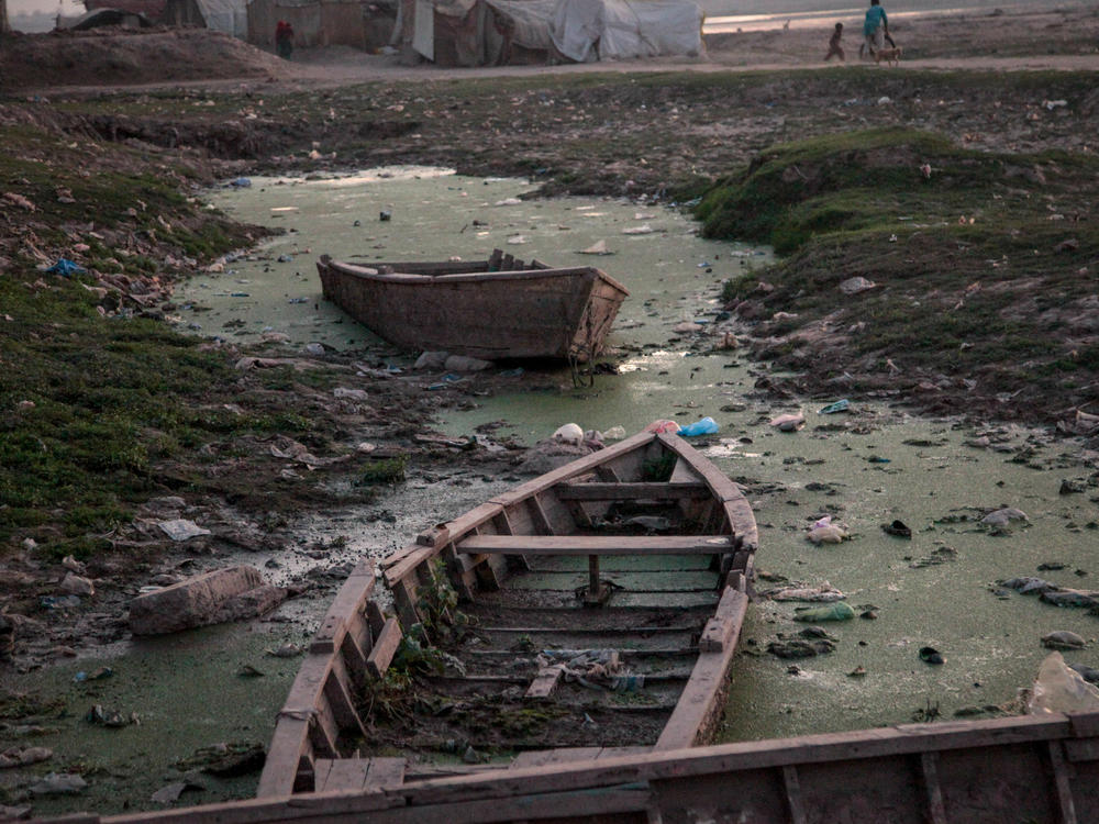Traditional fishing boats rot in stagnant pools of water beside the Ravi River bank in the Pakistani city of Lahore.