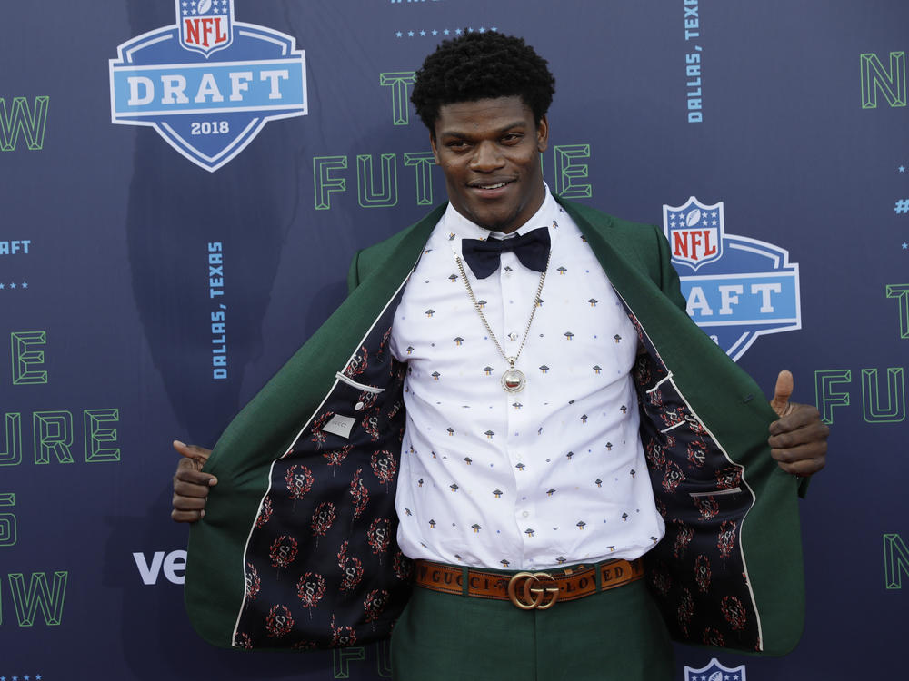 Lamar Jackson poses for photos on the red carpet before the first round of the NFL football draft April 26, 2018, in Arlington, Texas. Jackson complemented the rich green Gucci suit with a white UFO printed shirt by the designer, a signature Gucci belt and went Gucci down to the shoes.