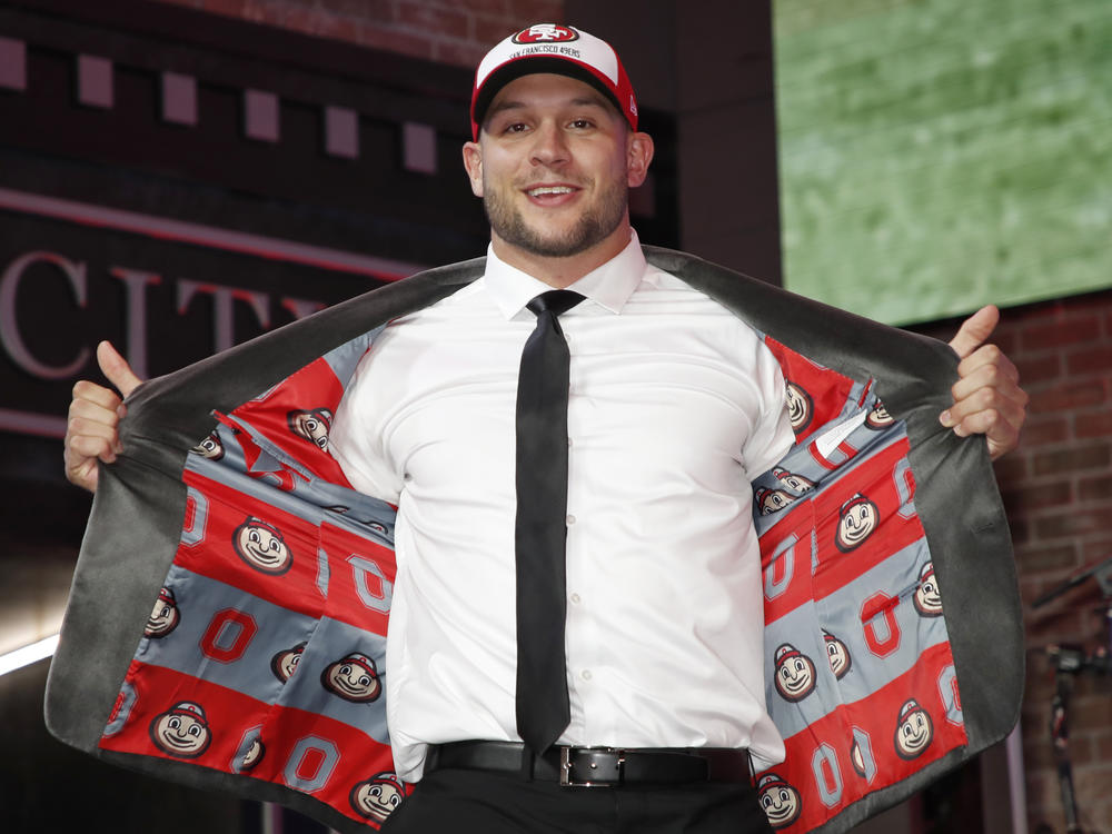 Defensive end Nick Bosa enters the main stage after the San Francisco 49ers selected him in the first round at the NFL football draft April 25, 2019, in Nashville, Tenn. Bosa delighted Ohio State fans everywhere by opening his gray suit jacket to reveal a lining covered with images of mascot Brutus Buckeye.