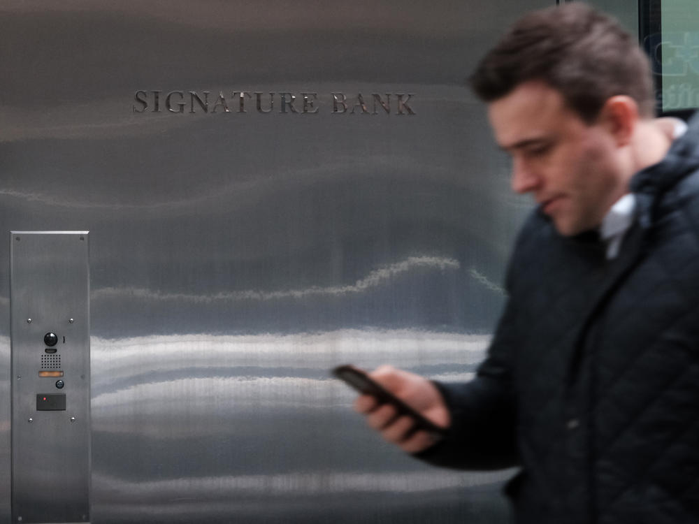 People walk by the Manhattan headquarters of Signature Bank, which was closed by bank regulators just days after Silicon Valley Bank collapsed. The FDIC is doing a review on what led to the failure of the New York-based lender.
