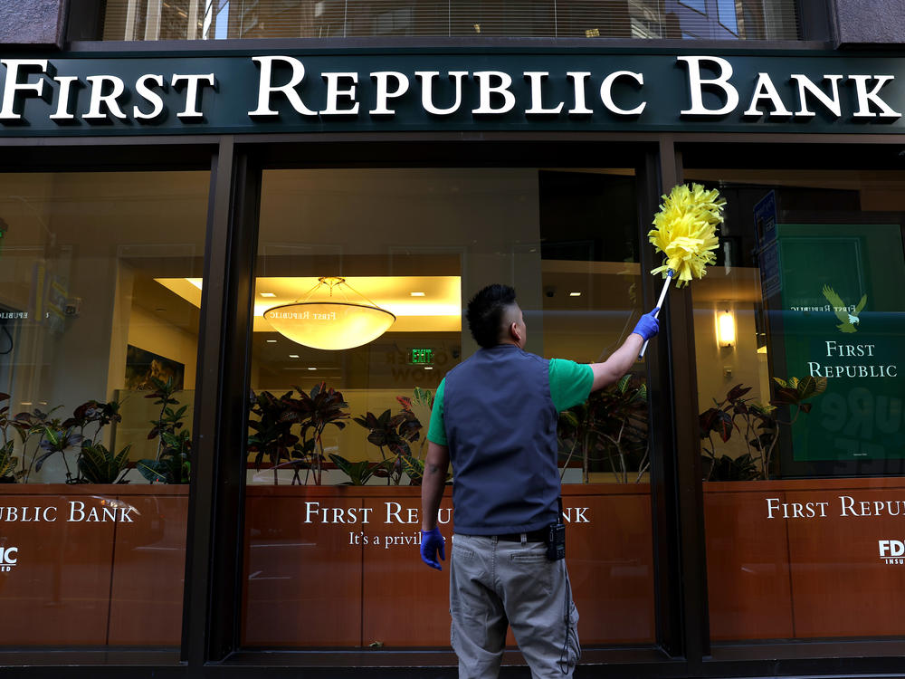 A worker cleans the outside of a First Republic bank in San Francisco. The lender was taken over by regulators and sold to JPMorgan Chase, marking the third bank failure in the country this year.