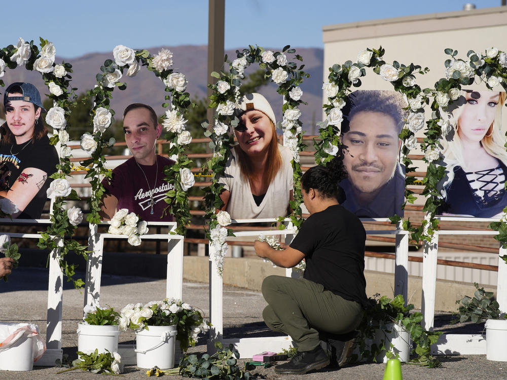 Noah Reich, left, and David Maldonado, the Los Angeles co-founders of Classroom of Compassion, put up a memorial Nov. 22, 2022, with photographs of the five victims of a weekend mass shooting at a nearby gay nightclub in Colorado Springs, Colo.