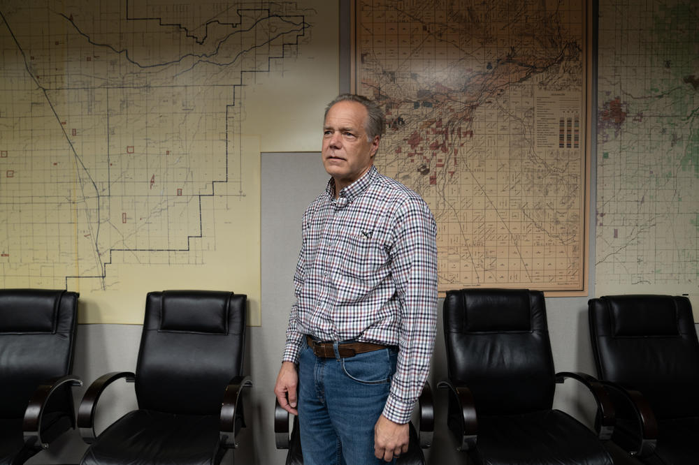 Mark Larsen stands in front of maps that show the Kaweah watershed as it was in 1885 (center), before people controlled the river's flow, and one from 100 years later (left).