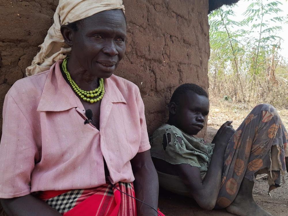 Ventorina Aculu of northern Uganda sits next to her adult son, Omac Alfred, who has a rare neurological disease known as nodding syndrome.