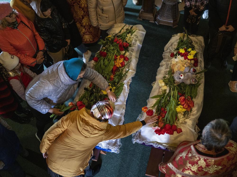 Mourners place flowers on the coffins of Sofia Shulha, 11, and Pysarev Kiriusha, 17, during a funeral in Uman, central Ukraine, Sunday. They were among more than 20 people killed during a Russian attack on a residential building early Friday morning.