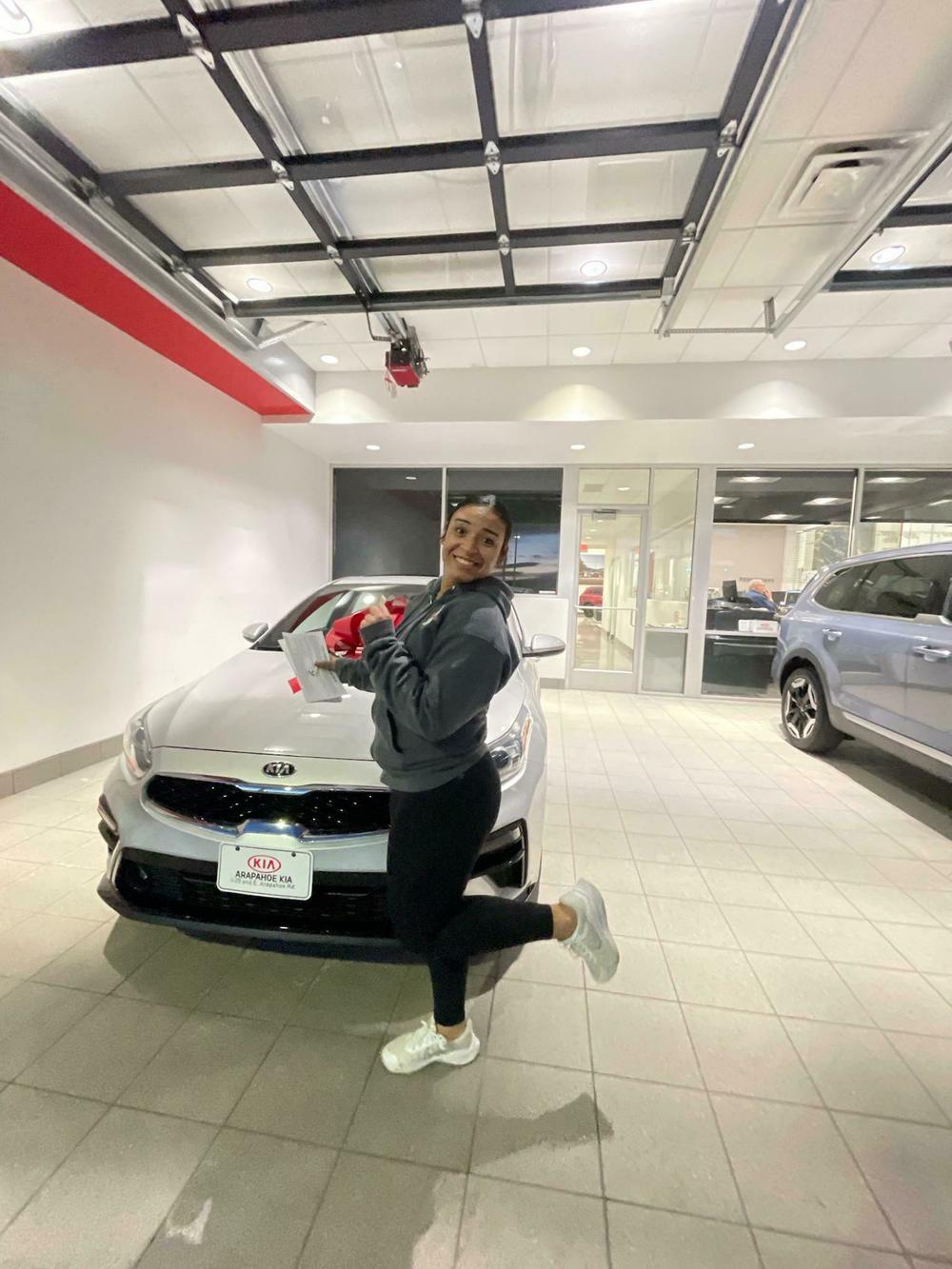 Reyna Garcia's daughter Kira Gray poses in front of the used Kia Forte the family recently bought.