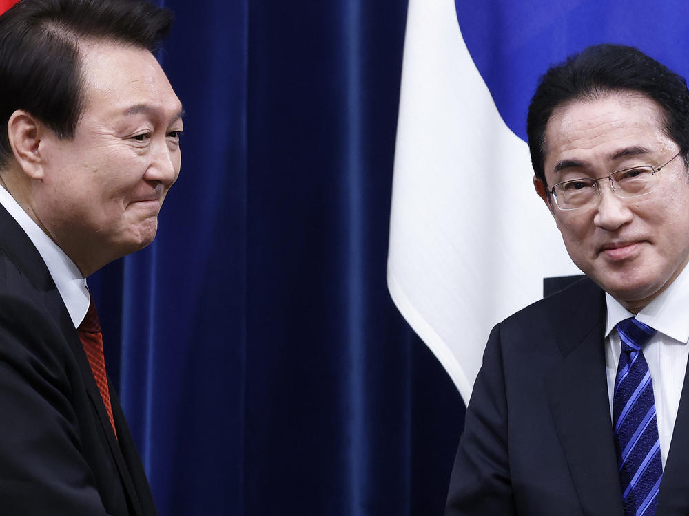 South Korean President Yoon Suk Yeol, left, and Japanese Prime Minister Fumio Kishida, right, shake hands following a joint news conference at the prime minister's office in Tokyo on March 16th.