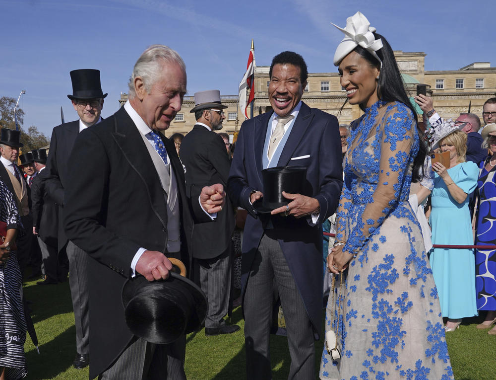 King Charles III laughs with American singer Lionel Richie and his girlfriend, Lisa Parigi, during a Wednesday garden party at Buckingham Palace in celebration of Saturday's coronation. Richie is among those performing at Sunday's Coronation Concert.